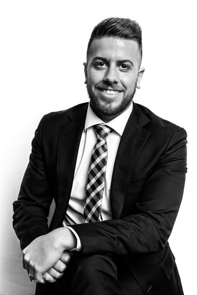 Headshot photo of Daniel Tassone from PCO Law sitting on a chair